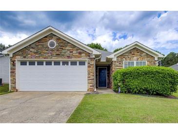 Charming single-story home featuring a stone facade, two-car garage, and well-manicured lawn at 10892 Big Sky Dr, Hampton, GA 30228