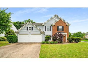 Charming two-story home featuring light blue siding, brick accents, a manicured lawn, and a two-car garage at 3471 Chastain Glen Ne Ln, Marietta, GA 30066