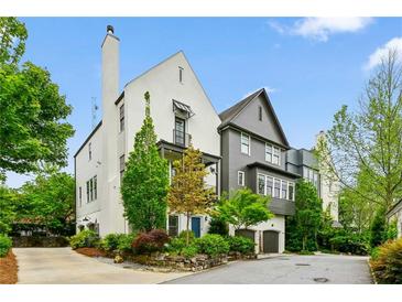 Charming home featuring a mix of white and gray exteriors, surrounded by mature trees and professionally landscaped grounds at 584 Bismark Ne Rd, Atlanta, GA 30324