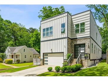Striking modern two-story home with stone accents, a well-manicured lawn, and a convenient attached garage at 2020 Bixby Se St, Atlanta, GA 30317
