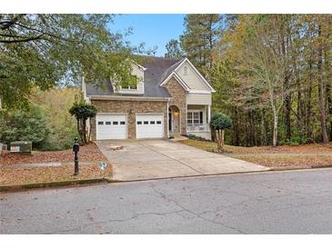 Charming two-story home featuring a stone facade, two-car garage, and well-maintained front yard at 100 Lantana Dr, Locust Grove, GA 30248