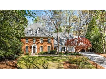 Stately brick home with dormer windows, well-manicured lawn and beautiful landscaping at 1285 Wesley Nw Pl, Atlanta, GA 30327