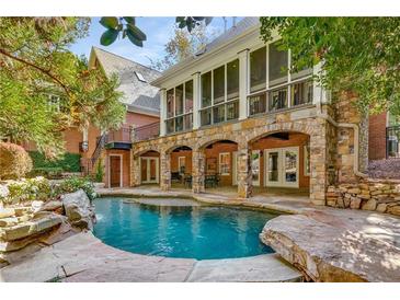 The backyard features a stunning pool, stone patio, and covered porch, perfect for outdoor entertaining and relaxation at 1285 Wesley Nw Pl, Atlanta, GA 30327