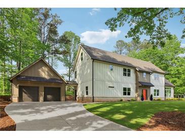 Beautiful two-story home with a large front yard, attached garage, and light colored facade at 4840 Moon Rd, Powder Springs, GA 30127
