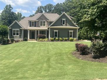 Charming two-story home with a manicured lawn and attractive stone and siding details at 121 Harmony Oaks Trl, Canton, GA 30115