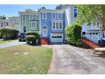 Charming multi-colored townhome with brick steps leading to a white front door and attached one car garage at 3716 Meeting St, Duluth, GA 30096