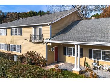 Charming home featuring a red door, black shutters, gray roof, and a cozy front porch seating area at 1468 Briarwood Ne Rd # 2003, Atlanta, GA 30319
