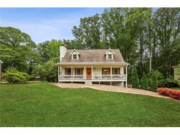 Charming home featuring a cozy front porch, well-manicured lawn, and beautifully landscaped surroundings at 1768 San Andra Dr, Marietta, GA 30062