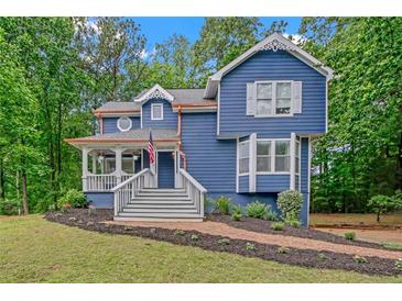 Charming blue two-story home featuring a welcoming front porch and lush, landscaped front yard at 4440 Coventry Ne Ct, Roswell, GA 30075