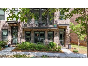 Charming brick townhouse with a cozy balcony and well-maintained landscaping offering curb appeal at 1626 Aldworth Se Pl, Atlanta, GA 30339