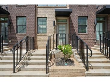 Brick townhome entrance with concrete steps, black railings, and a covered doorway at 230 New St # 2102, Decatur, GA 30030