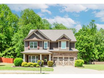 Charming two-story home with a stone-accented facade, landscaped yard, and attached two-car garage at 674 Chadmon Court Trce, Dacula, GA 30019
