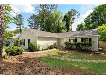 Charming single-story home with a well-maintained lawn, established landscaping and neutral color palette at 102 River Oaks Dr, Woodstock, GA 30188