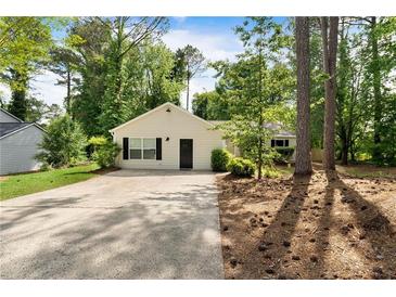 Charming single-story home with a well-maintained yard and a long driveway leading to the front entrance at 102 River Oaks Dr, Woodstock, GA 30188