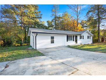 Charming home featuring a freshly painted exterior, ample parking, and a well-maintained front yard at 4781 Brownsville Rd, Powder Springs, GA 30127
