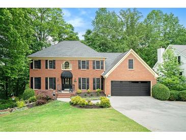 Charming brick home with well-manicured lawn and mature trees offering great curb appeal at 5020 Huntshire Sw Ln, Lilburn, GA 30047