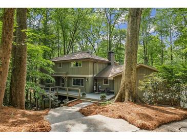 Beautiful two-story home with a deck nestled amongst lush trees at 1050 Mountain Creek Trl, Atlanta, GA 30328