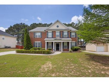 Charming two-story brick home with manicured lawn and lush landscaping at 110 Village Green Cir, Tyrone, GA 30290