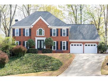 Charming two-story red brick home with a three-car garage and well-maintained landscaping at 4344 White Surrey Nw Dr, Kennesaw, GA 30144