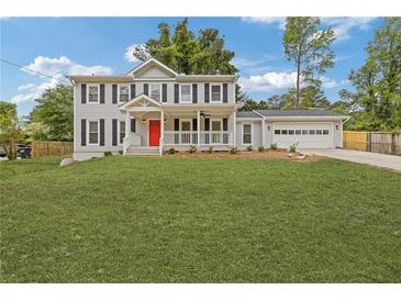 Charming two-story home with a bright red front door and covered porch at 565 Deer Sw Run, Lilburn, GA 30047