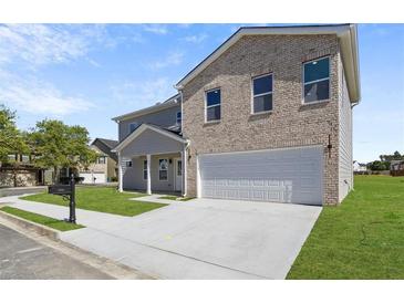 Charming two-story home featuring a light brick facade and a spacious two-car garage at 3634 Oakleaf Pass, Fairburn, GA 30213