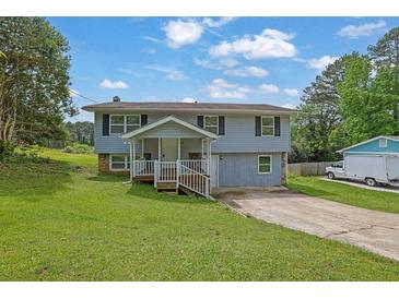 Charming two-story home features a welcoming front porch and a well-maintained lawn at 4665 Big Valley Rd, Stone Mountain, GA 30083