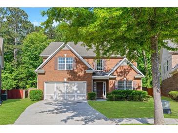 Charming brick home with a well-manicured lawn, two-car garage, and mature trees in a Gathering-friendly neighborhood at 4353 Pond Edge Rd, Snellville, GA 30039