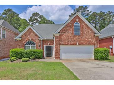 Charming red brick home with a manicured lawn and a two-car garage at 735 Scenic Creek Dr, Lawrenceville, GA 30046