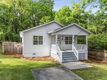 Charming cottage-style home with a welcoming front porch and well-maintained lawn surrounded by mature trees at 1596 Foote Ne St, Atlanta, GA 30307