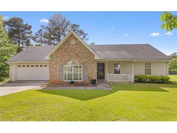 Charming brick and siding home featuring a manicured lawn and an attached two-car garage at 129 Lakepointe Ct, Stockbridge, GA 30281
