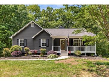 Charming single-story home with gray siding, a covered front porch, and attractive landscaping at 588 Peachtree Se Dr, White, GA 30184