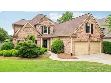 Charming brick home with a well-manicured lawn and a two-car garage, offering classic curb appeal at 1545 Center Cross Pass, Marietta, GA 30062