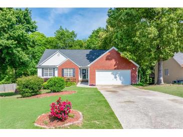 Charming single-story brick home featuring a well-manicured front yard and attached garage at 1720 Alcovy River Dr, Dacula, GA 30019