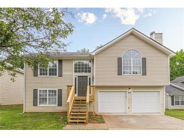 Charming two-story home featuring a two-car garage, inviting entrance, and well-maintained landscaping at 3022 Stonebridge Creek Dr, Lithonia, GA 30058
