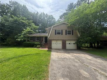 Charming two-story home featuring a brick and vinyl facade, a two-car garage, and a well-manicured front lawn at 4135 Moore Rd, Conley, GA 30288