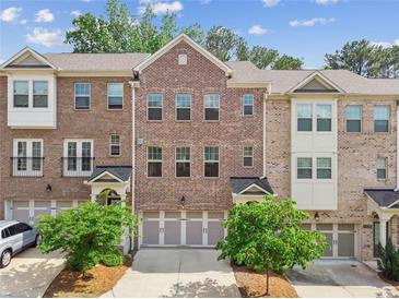 Charming brick townhome featuring a two-car garage and well-maintained landscaping at 1327 Rosen Rd, Brookhaven, GA 30319