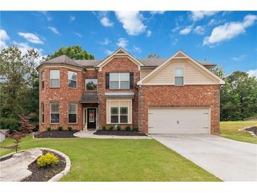 Charming two-story brick home with a well-manicured lawn and attached two-car garage at 1934 Acorn Ln, Dacula, GA 30019