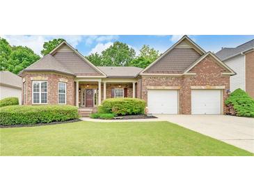 Charming brick home with a well-manicured lawn and a two-car garage, perfect for Gathering living at 3020 Crooked Stick Dr, Cumming, GA 30041