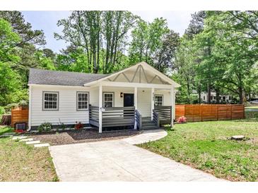 Inviting home with a well-maintained lawn, mature trees, and a charming covered porch at 2195 Penelope Nw St, Atlanta, GA 30314