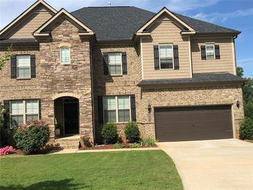 Beautiful two-story home with a well-maintained lawn, stone and brick facade and a two car garage at 292 Aylesbury Bv, Mcdonough, GA 30252