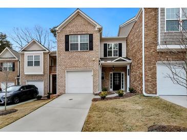 Charming brick townhome featuring a one-car garage and inviting front entrance at 11112 Benton Woods Dr, Covington, GA 30014