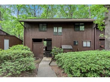 Two story house with brown siding and well-kept landscaping, situated in a serene, wooded setting at 1668 Terrell Ridge Se Dr, Marietta, GA 30067