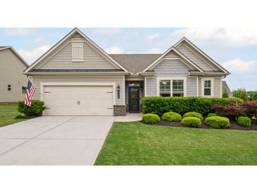 Charming home featuring a well-manicured lawn, a two-car garage, and an inviting entryway at 5775 Stellata Cir, Cumming, GA 30028