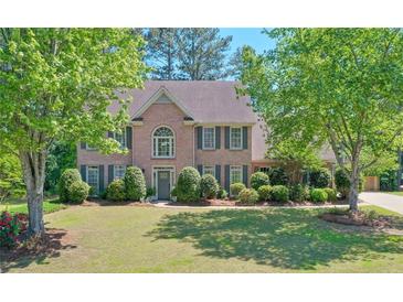 Charming two-story brick home with a well-manicured lawn and mature trees, offering great curb appeal at 630 Silverberry Ln, Sugar Hill, GA 30518