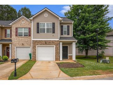 Inviting townhome with a well-manicured lawn, brick accents and a one-car garage at 3565 Brycewood Dr, Decatur, GA 30034