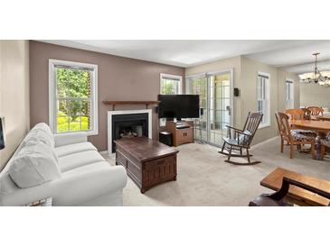 Comfortable living room with fireplace, plush white sofa, and bright windows at 5626 River Heights Se Xing, Marietta, GA 30067