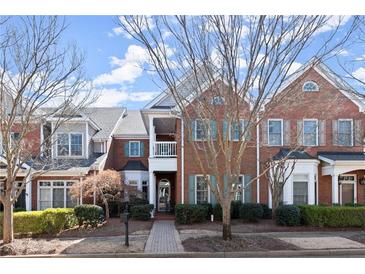Beautiful brick townhome featuring manicured landscaping and mature trees in an inviting neighborhood at 8730 Parker Pl, Roswell, GA 30076