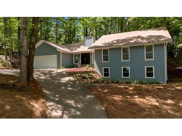 Charming home with a manicured front yard, long driveway, and attached two-car garage at 115 Lake Pines Ct, Roswell, GA 30076