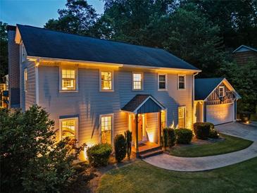 Illuminated two-story home showing front yard, manicured bushes, basketball hoop over garage, and inviting walkway to the front door at 3912 Edenton Ne Ct, Brookhaven, GA 30319