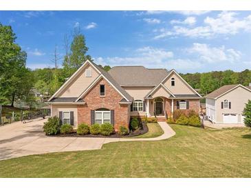 Charming brick and siding home with lush lawn and manicured landscaping and convenient side-entry garage at 2191 Lakeview Pkwy, Villa Rica, GA 30180